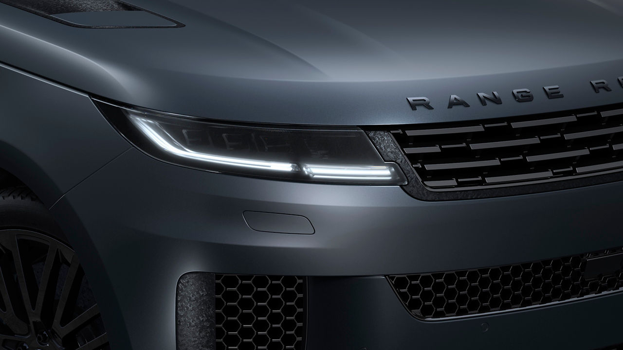 A close-up of the front end of a black Range Rover, emphasizing its sleek design 