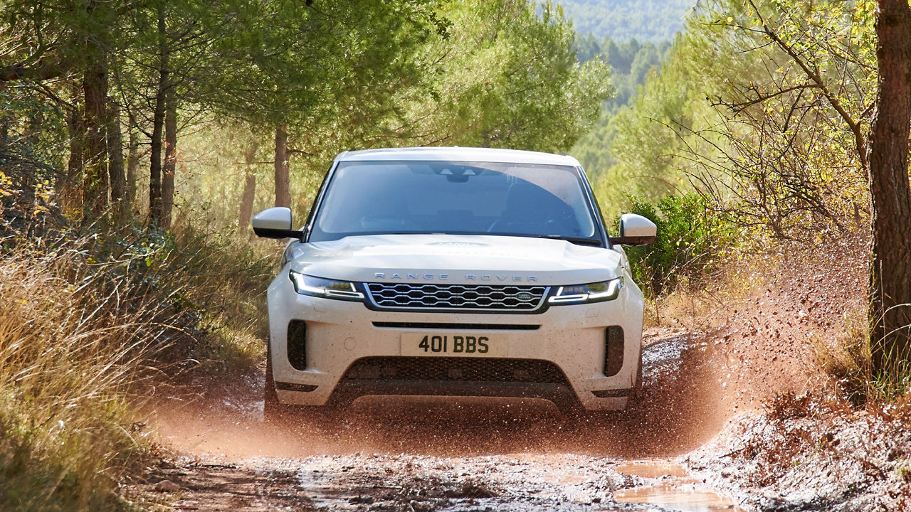 Range Rover Evoque crossing mud water on the test road in forest area