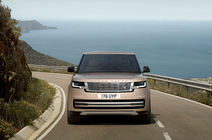 Range Rover running on mountain road surrounded with sea