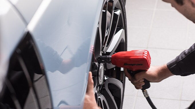 Someone changing the wheel of a car