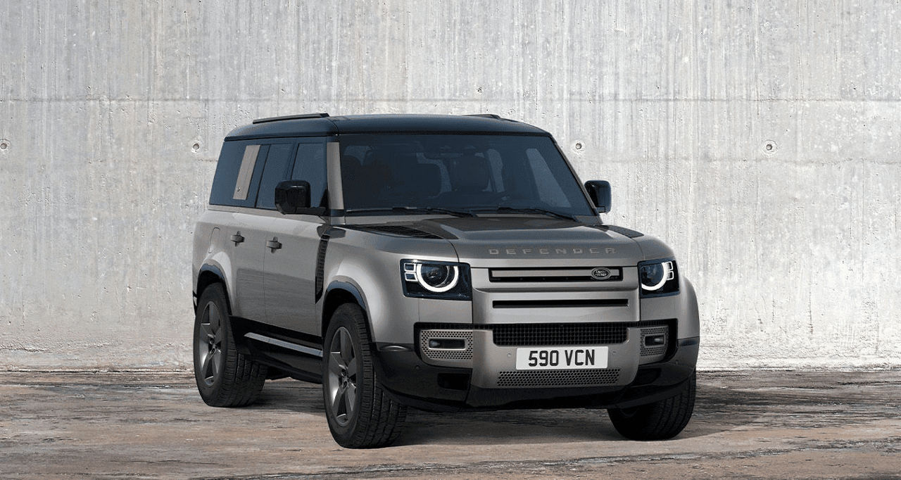 Side view of the Landrover Defender against a white cement wall