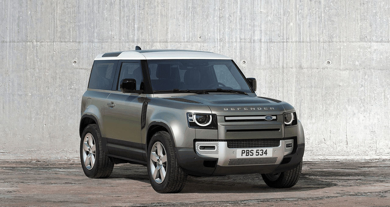 Side view of the Landrover Defender against a white cement wall