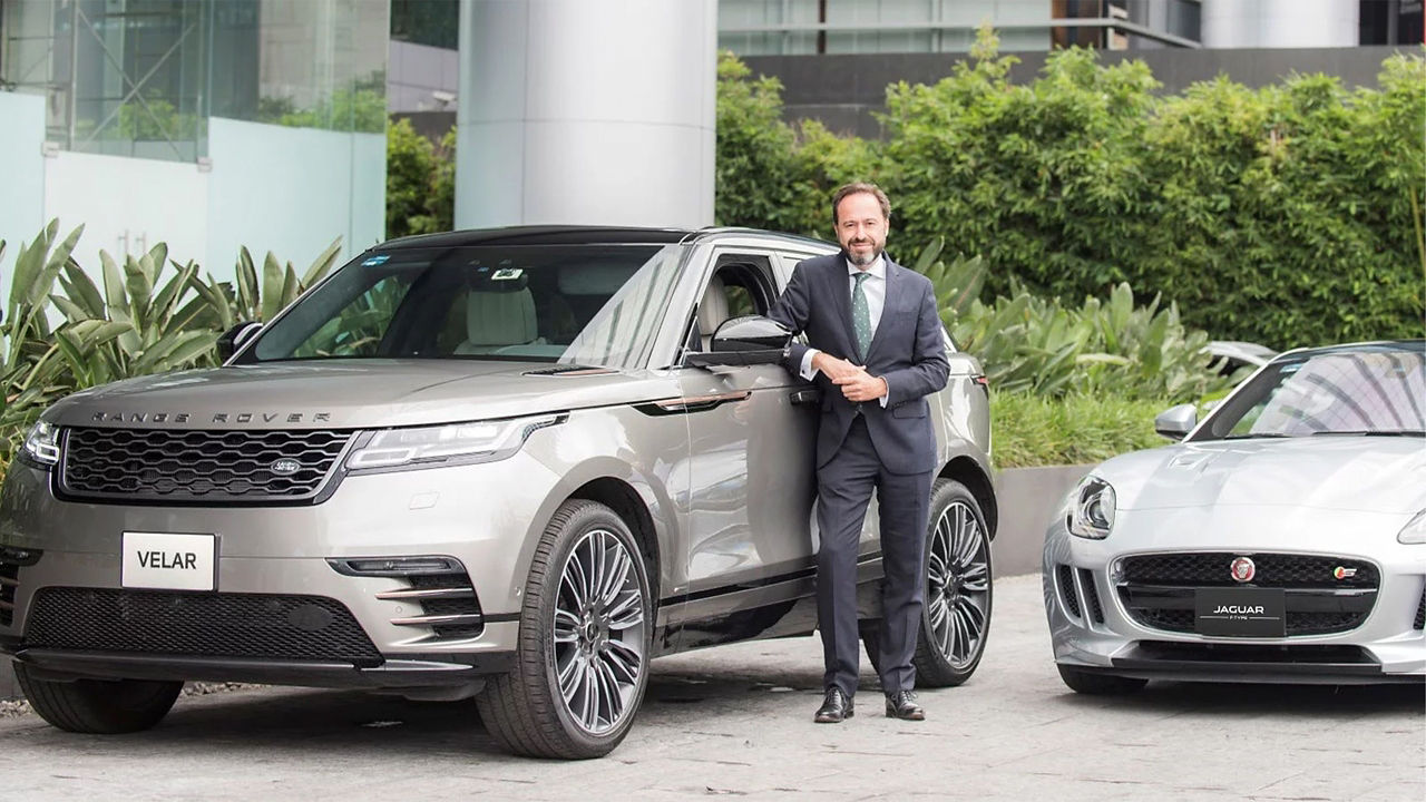 Man posing on left side with Range Rover Velar and Jaguar F-TYPE