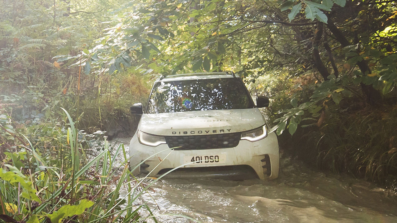 Driving Discovery through mud water in forest 