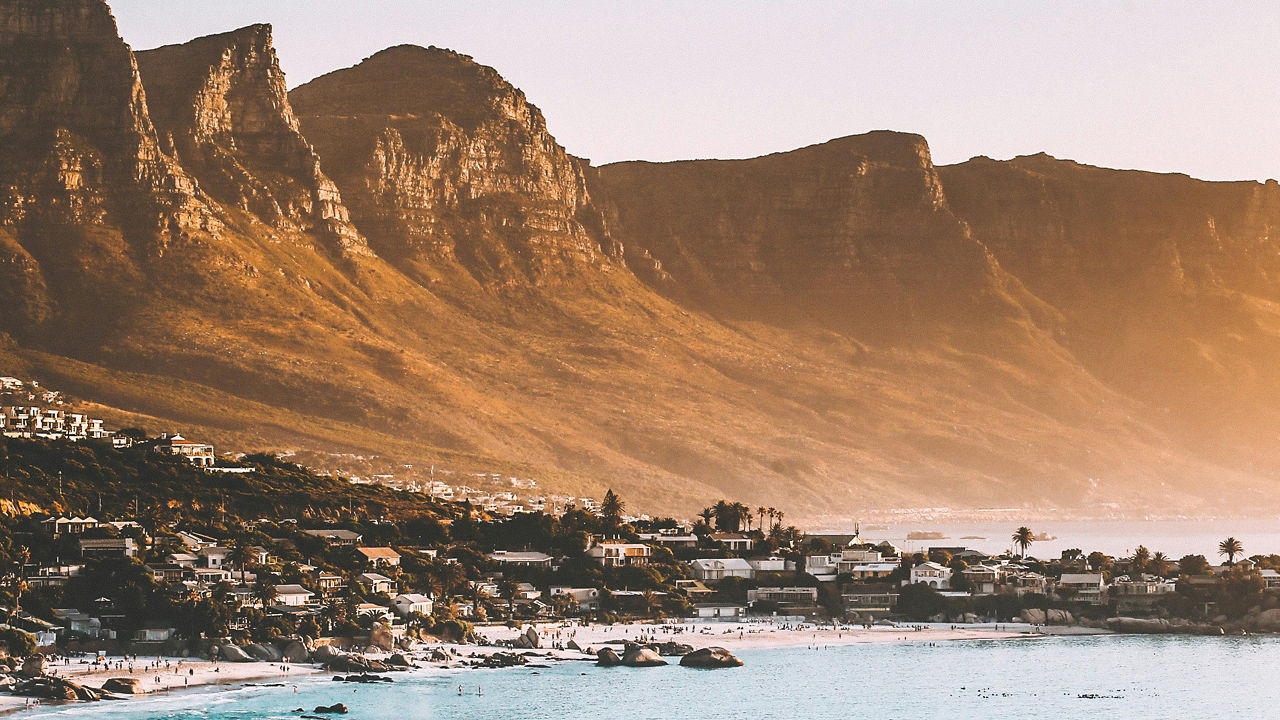 Snowy town at the base of brown rocky mountains.