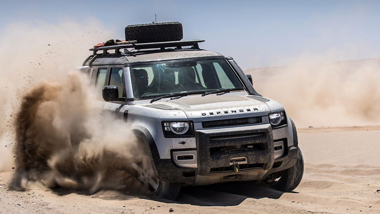 New Land Rover Defender Moving on a off-road on sand and desert terrain.