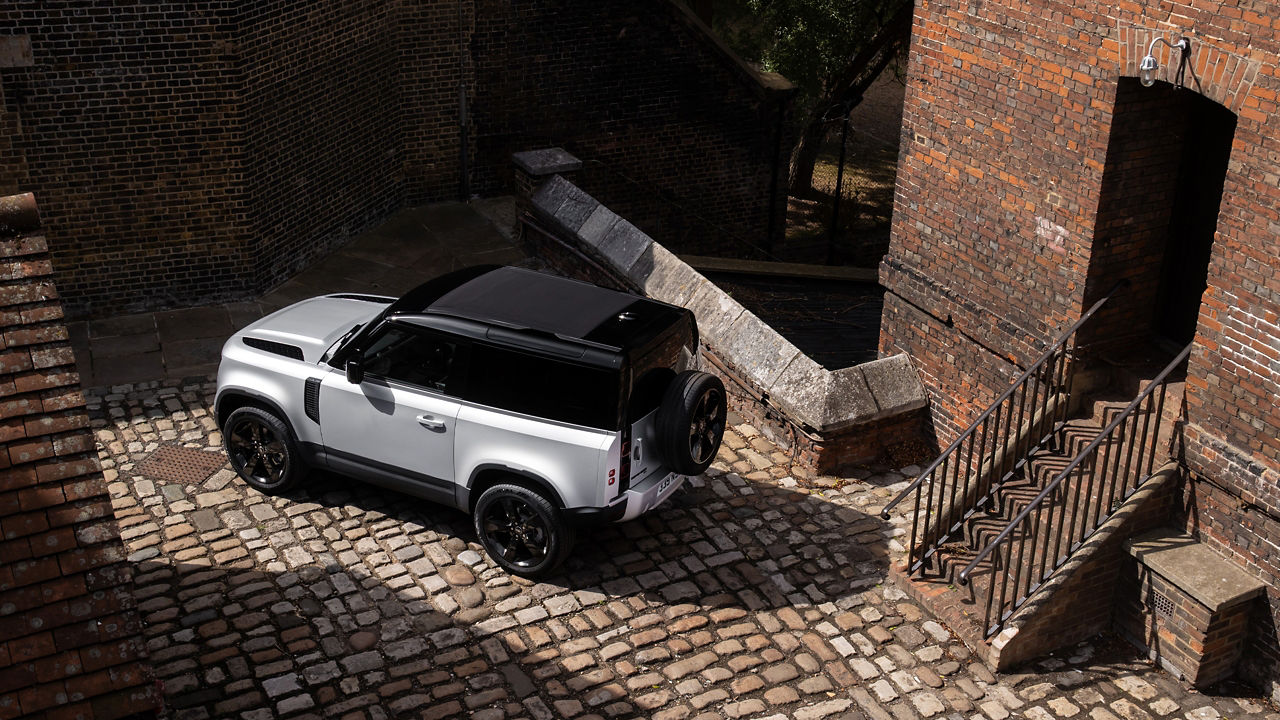 Parked defender on cobble stones near building