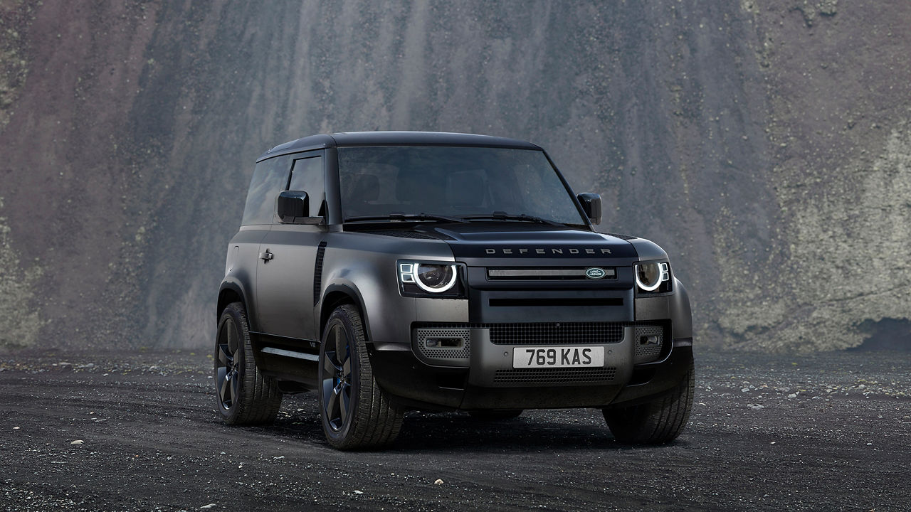 Parked defender on off-road and stone hill background