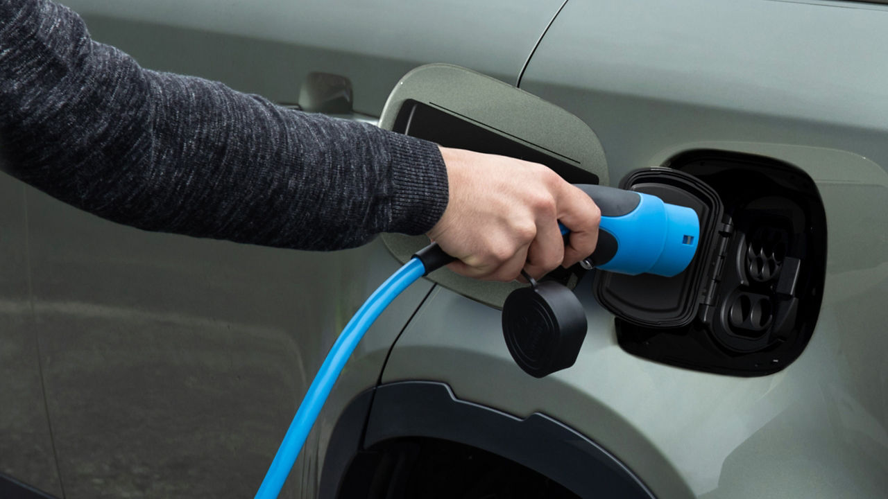 Man with inserting the charger in phev vehicle