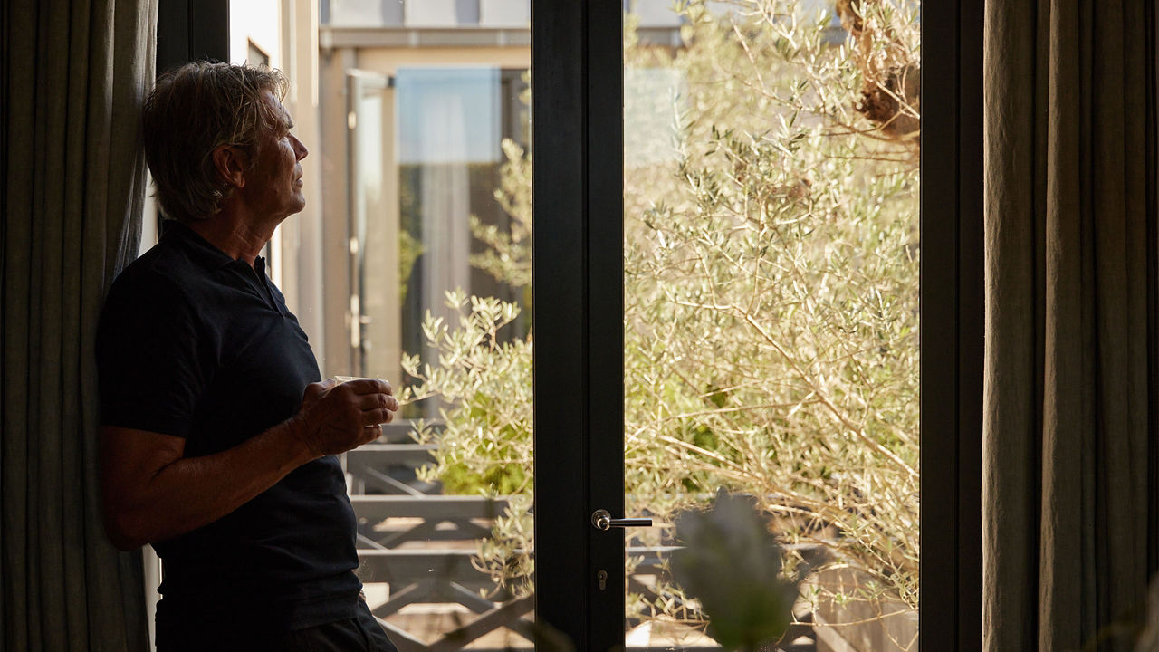 Man overseeing outside view with a cup of coffee