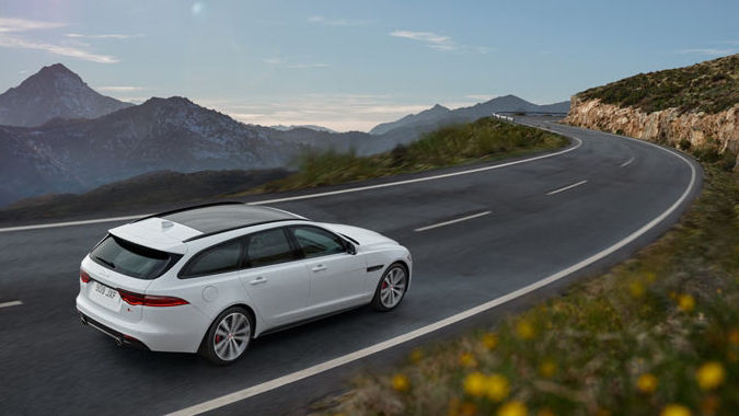 White Jaguar driving on road.