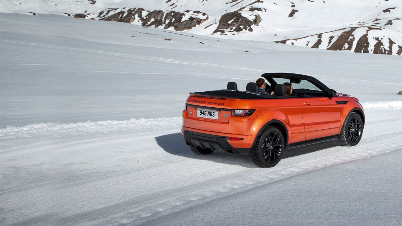 Convertible Range Rover Evoque driving on snowy mountain trail