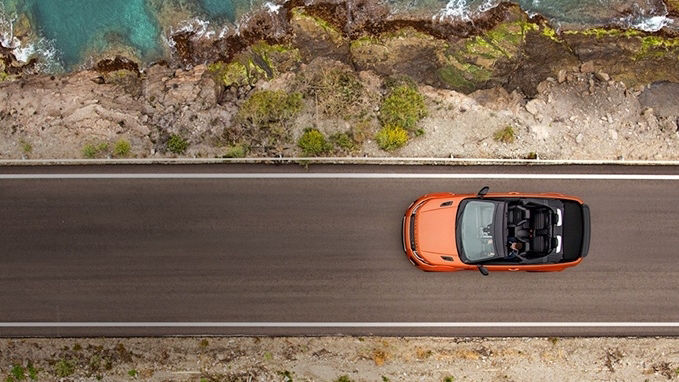 Convertible Range Rover Evoque driving on seaside road