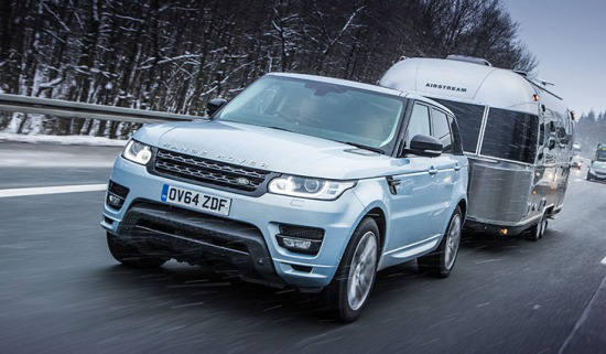 Range Rover driving with trailer attached 