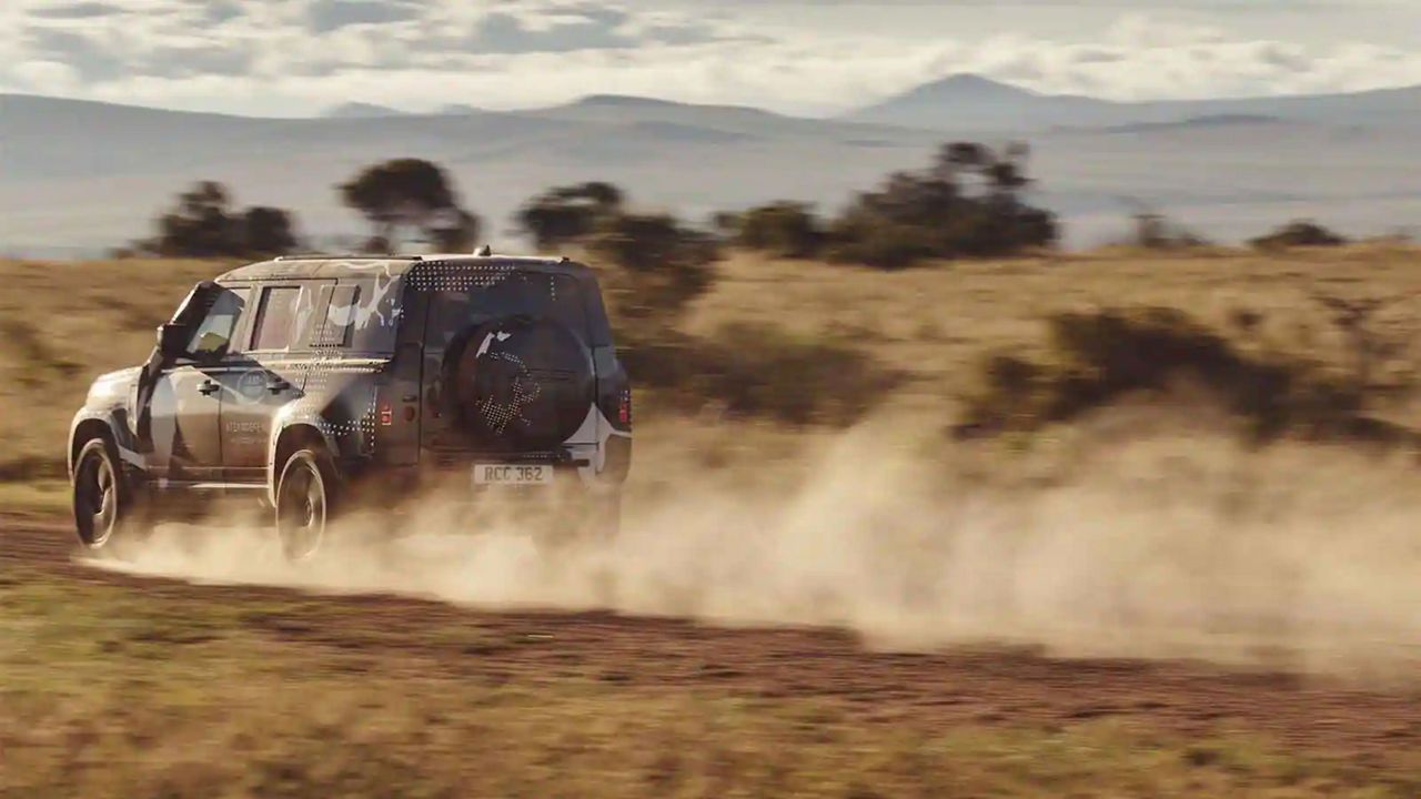 Defender driving down a road