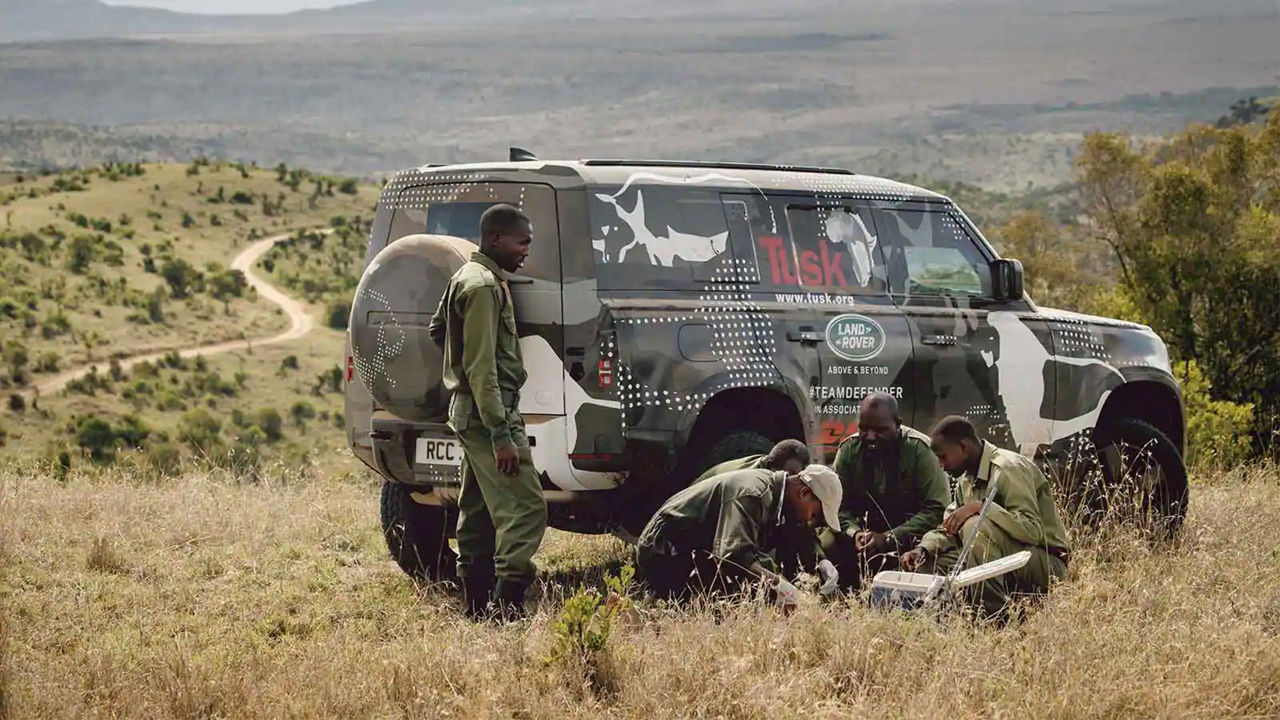 Group of men gathering next to their Defender