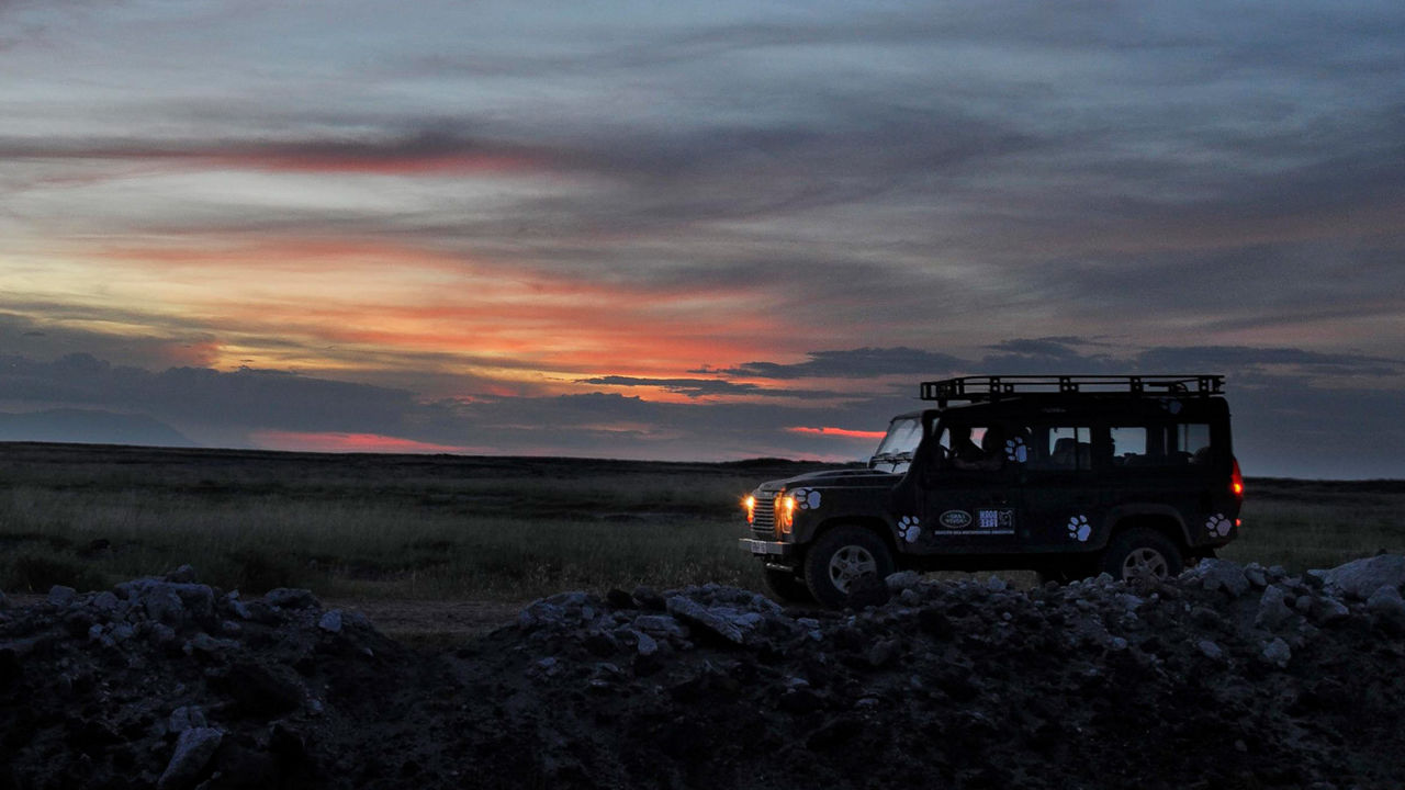 Classic Land Rover parked on rocky landscape