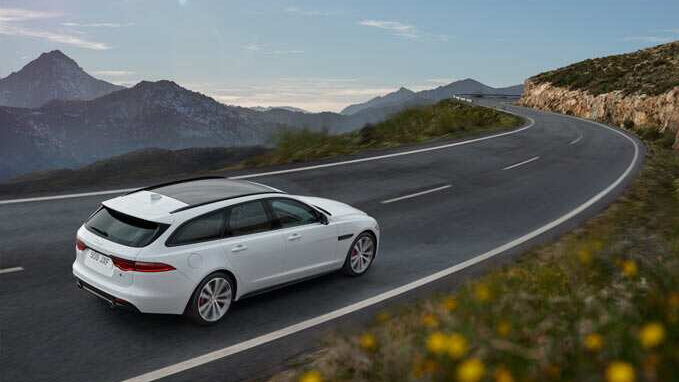 White Jaguar running on mountain road