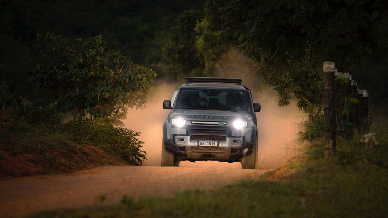 Defender driving towards camera with headlights on