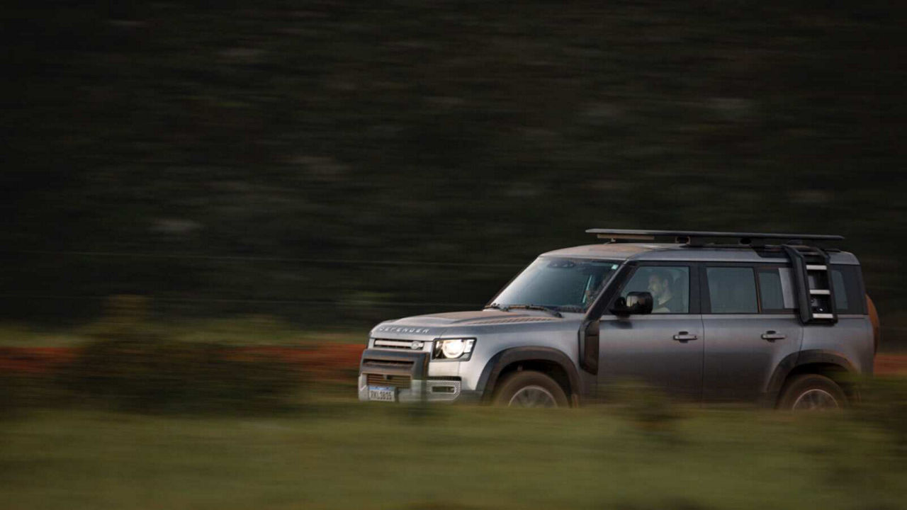 Defender driving down a road
