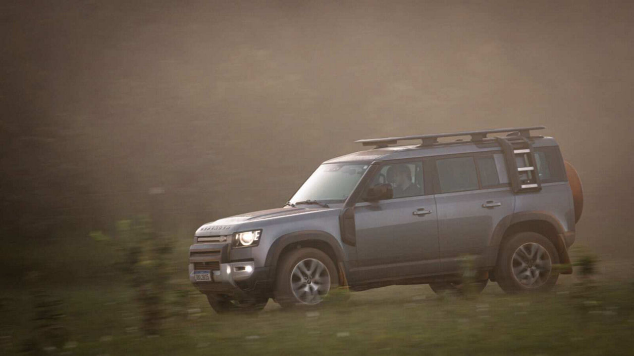 Defender driving down a road