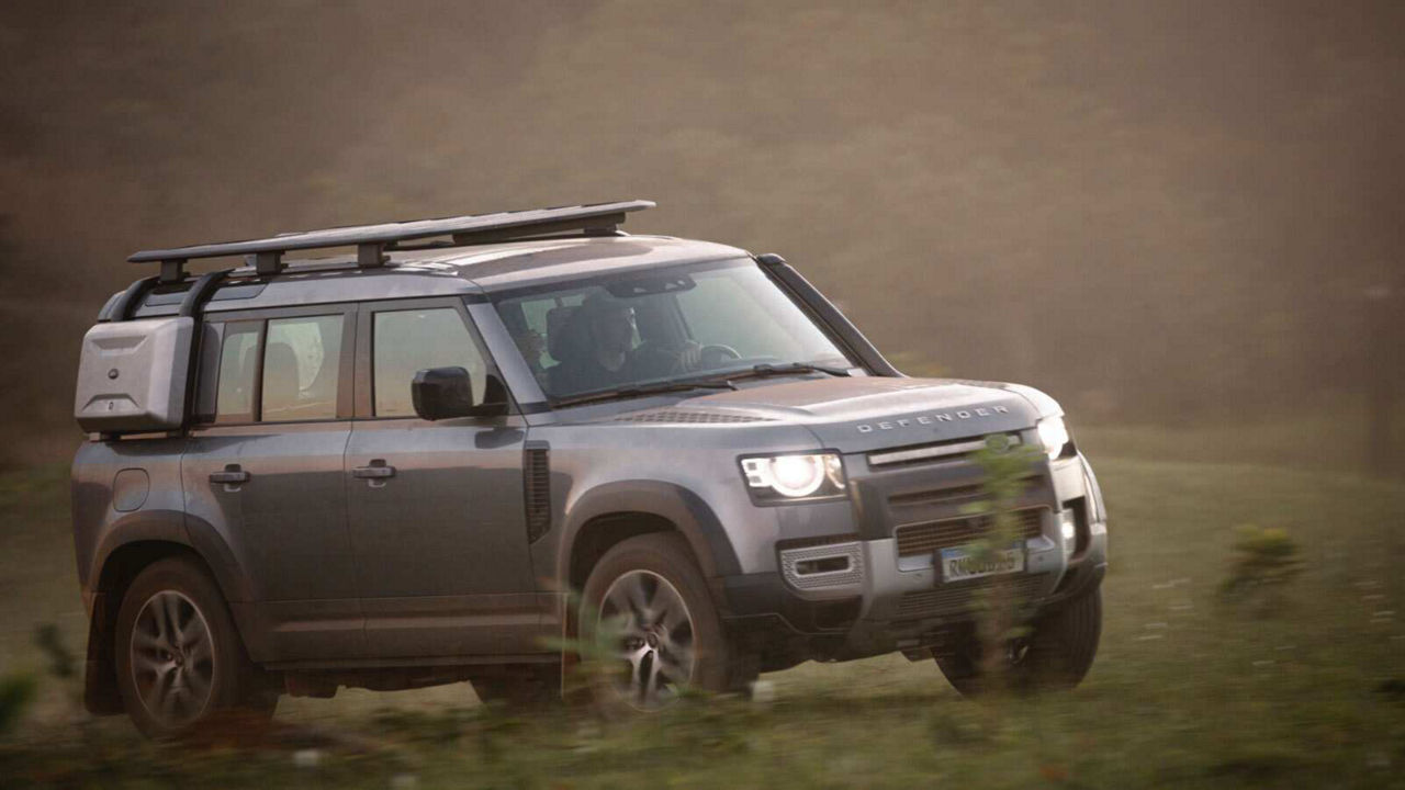 Defender driving down a road
