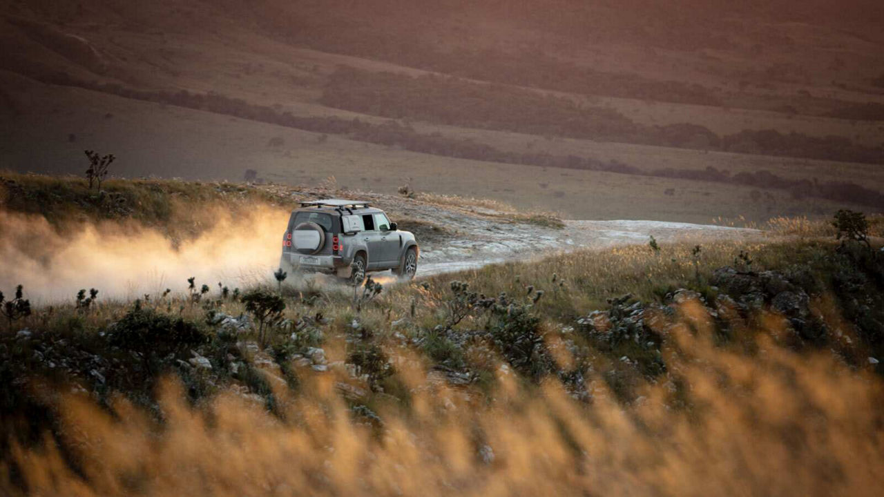 Defender driving down a road