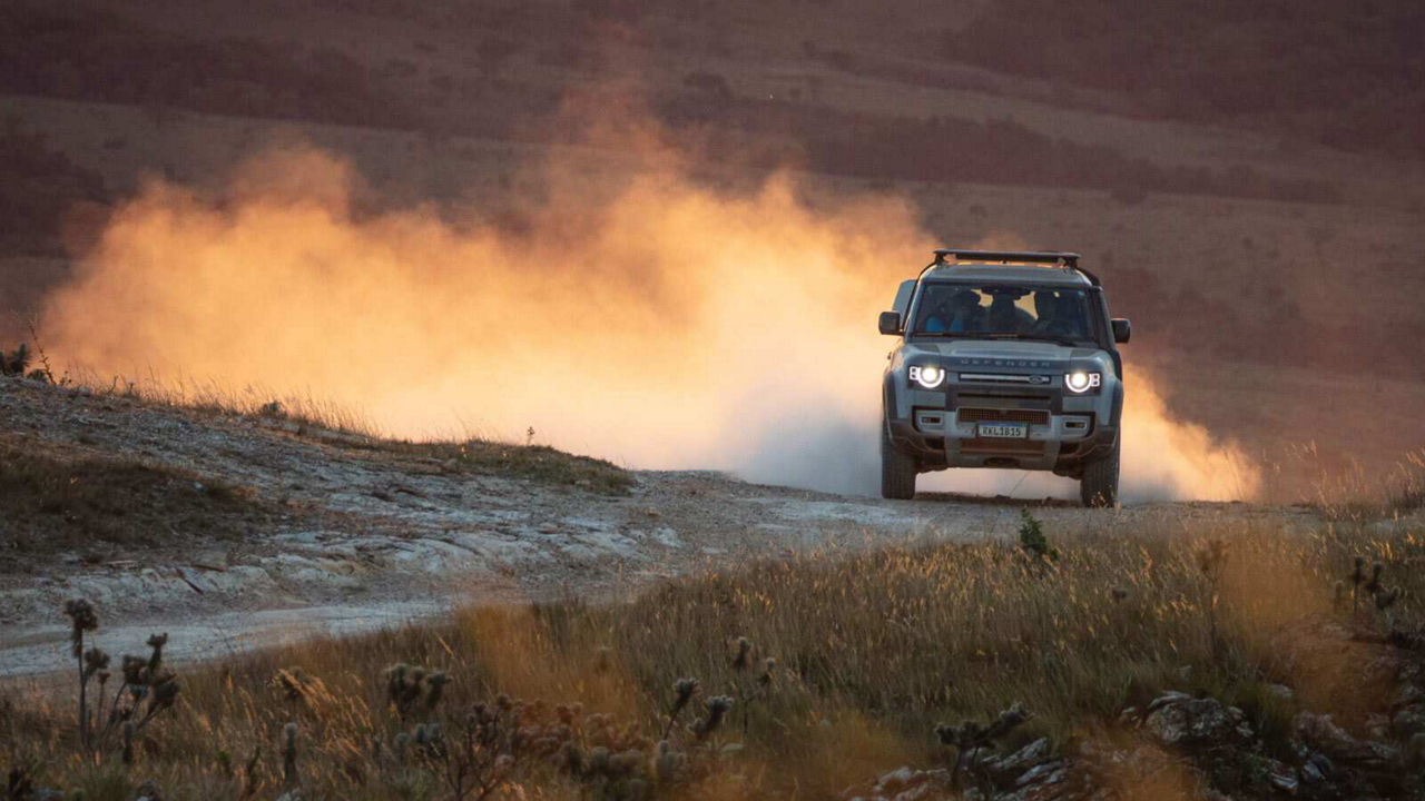 Defender driving towards camera with headlights on