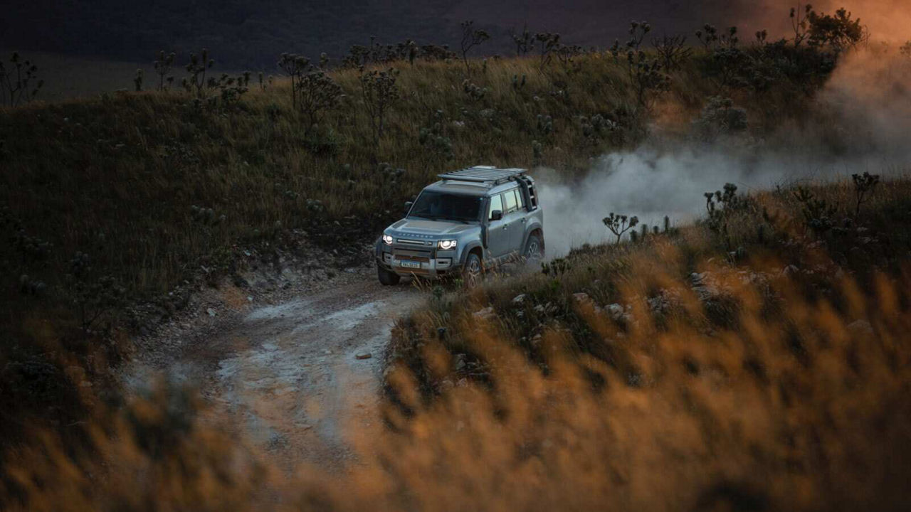 Defender driving down a road