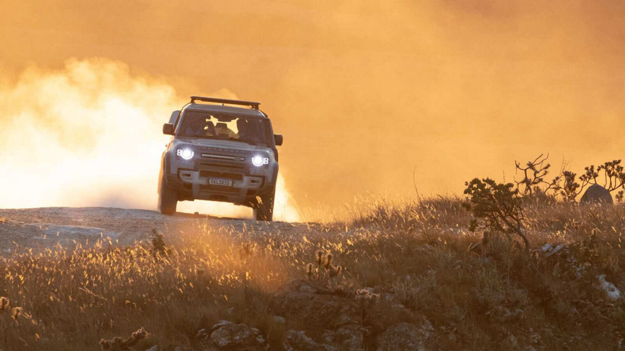 Defender driving towards camera with headlights on
