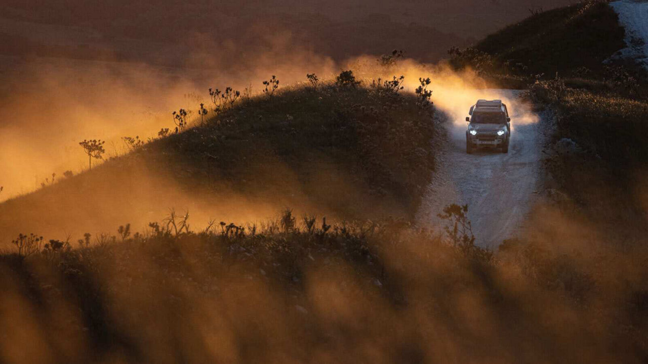 Defender driving down a road