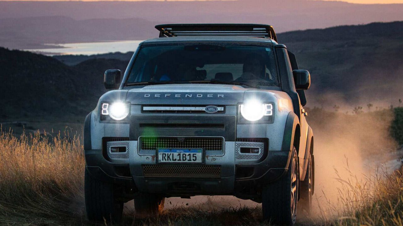 Defender driving towards camera with headlights on
