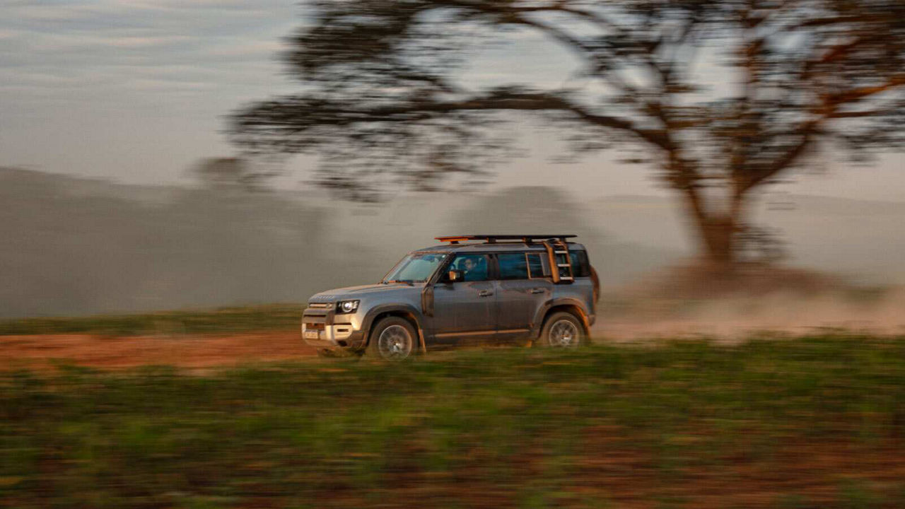 Defender driving fast on a road