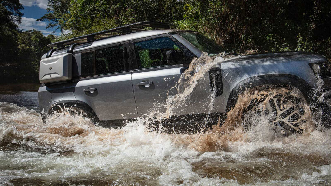Defender driving through a river