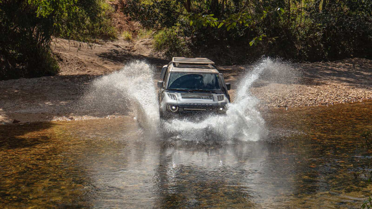 Defender driving through a river