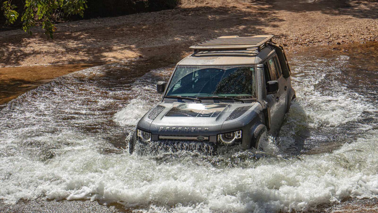 Defender driving through a river