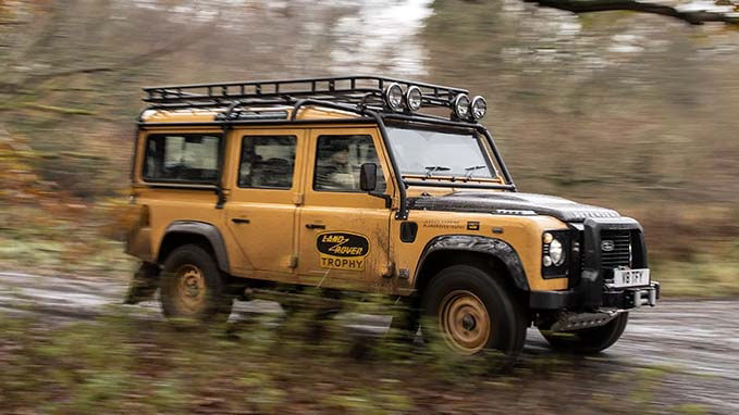 Classic Land Rover Defender driving on road