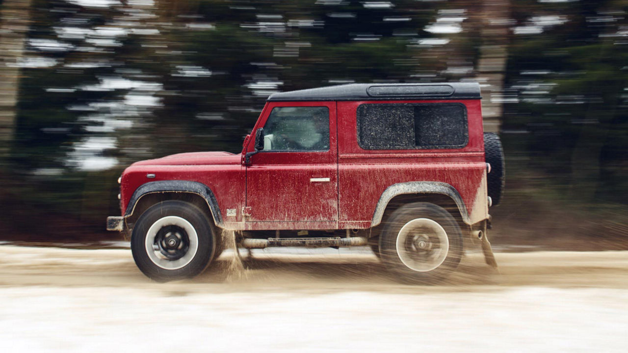 Land Rover Defender Works V8 driving on dirt road