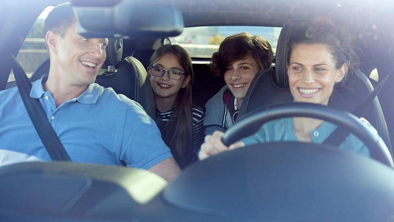 Happy family in a Jaguar car while driving