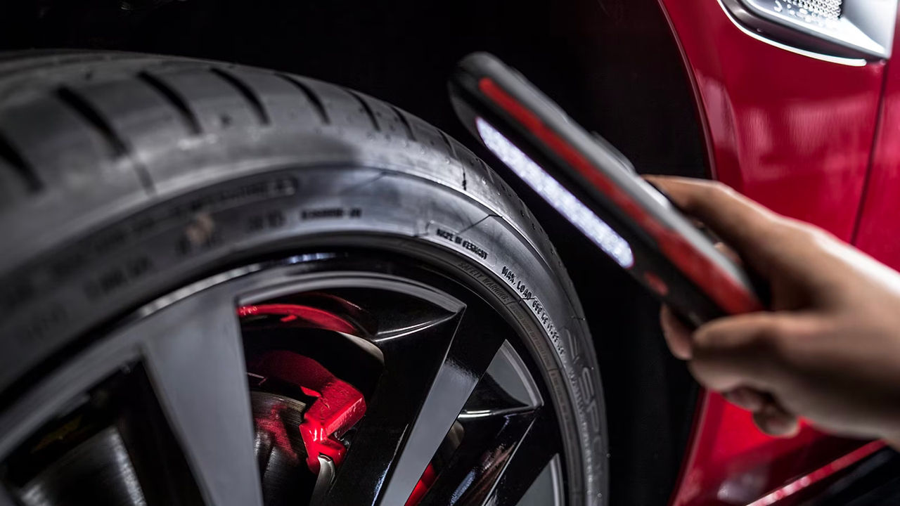 Hardworking experienced worker holding tire and selective focus on tire