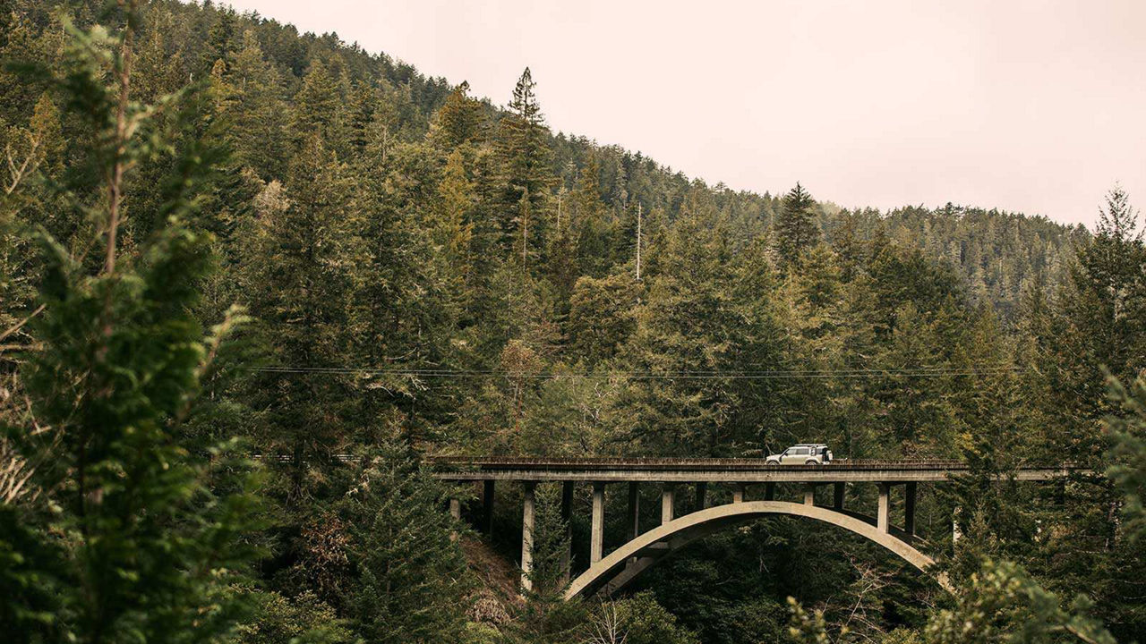 John Mayer Land Rover Defender driving on a bridge