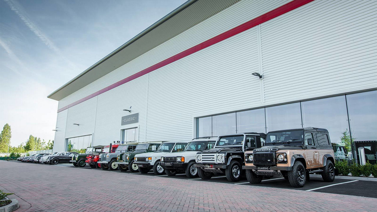 Classic Land Rovers lined up outside facility 
