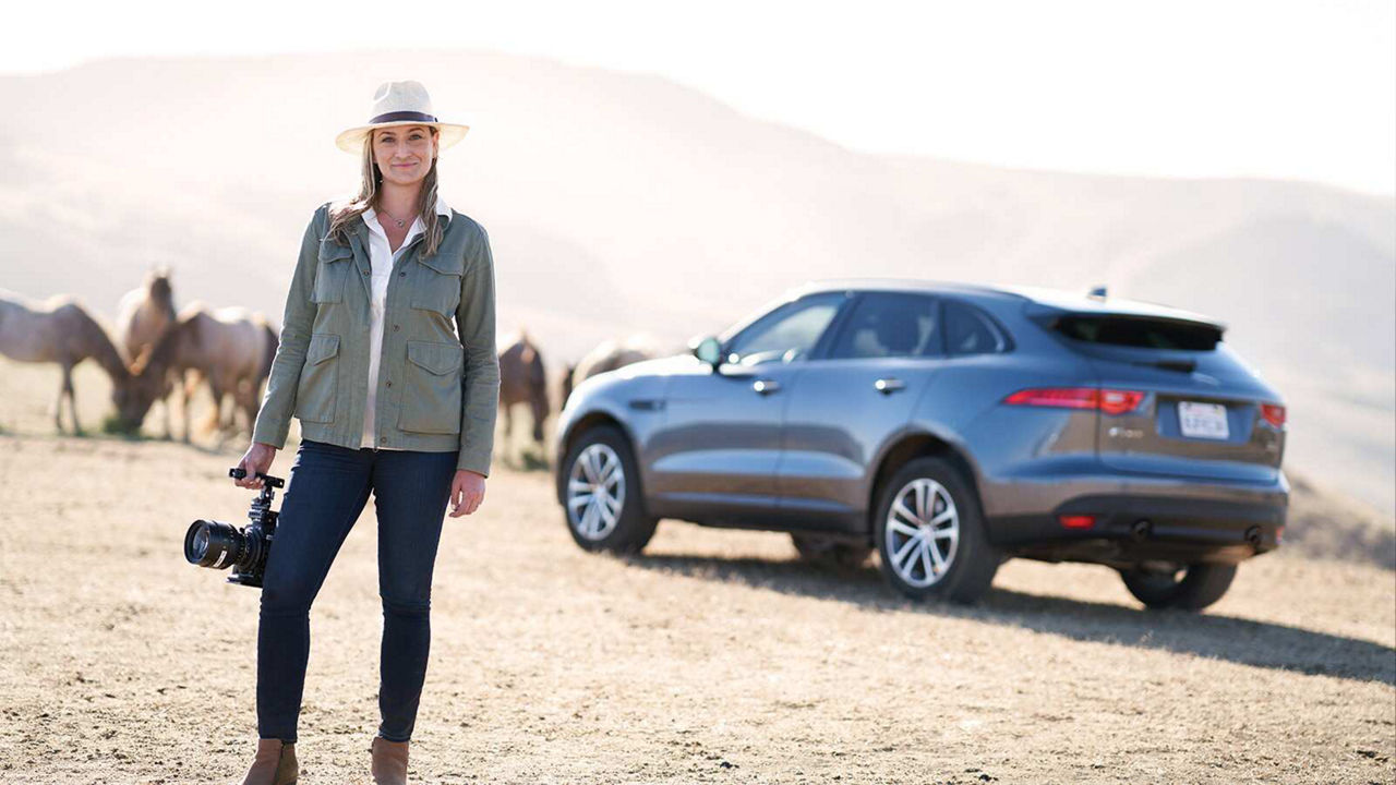 Ashley holding a camera near her F-Pace