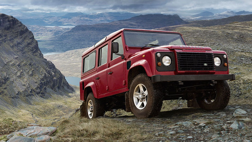 Classic Land Rover Defender parked on rocky hillside