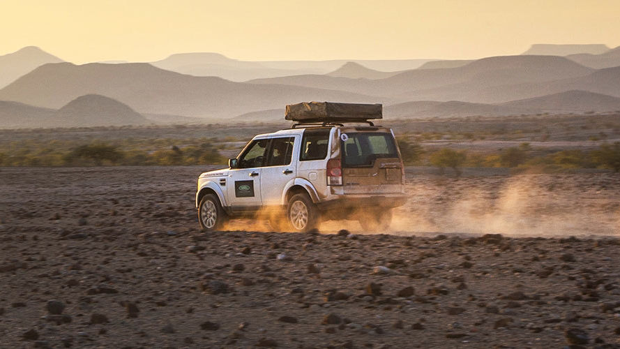 Land Rover Discovery driving through rocky desert