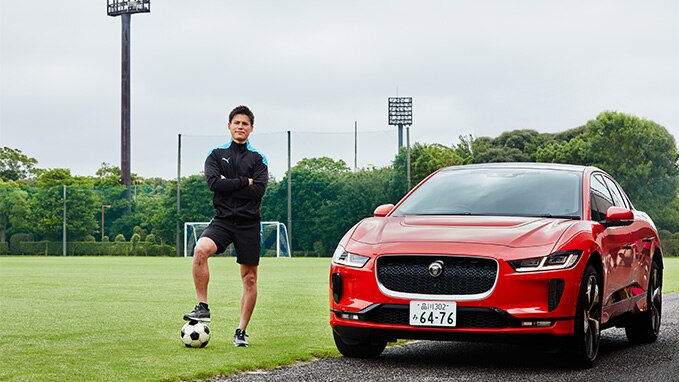 man playing football in-front of JAGUAR