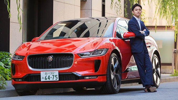 man posing for photo in-front of Red JAGUAR