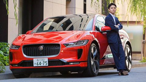 man posing for photo in-front of Red JAGUAR