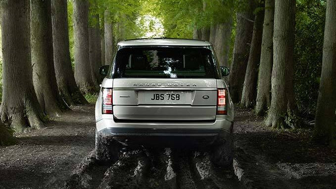 Range Rover driving on muddy forest path