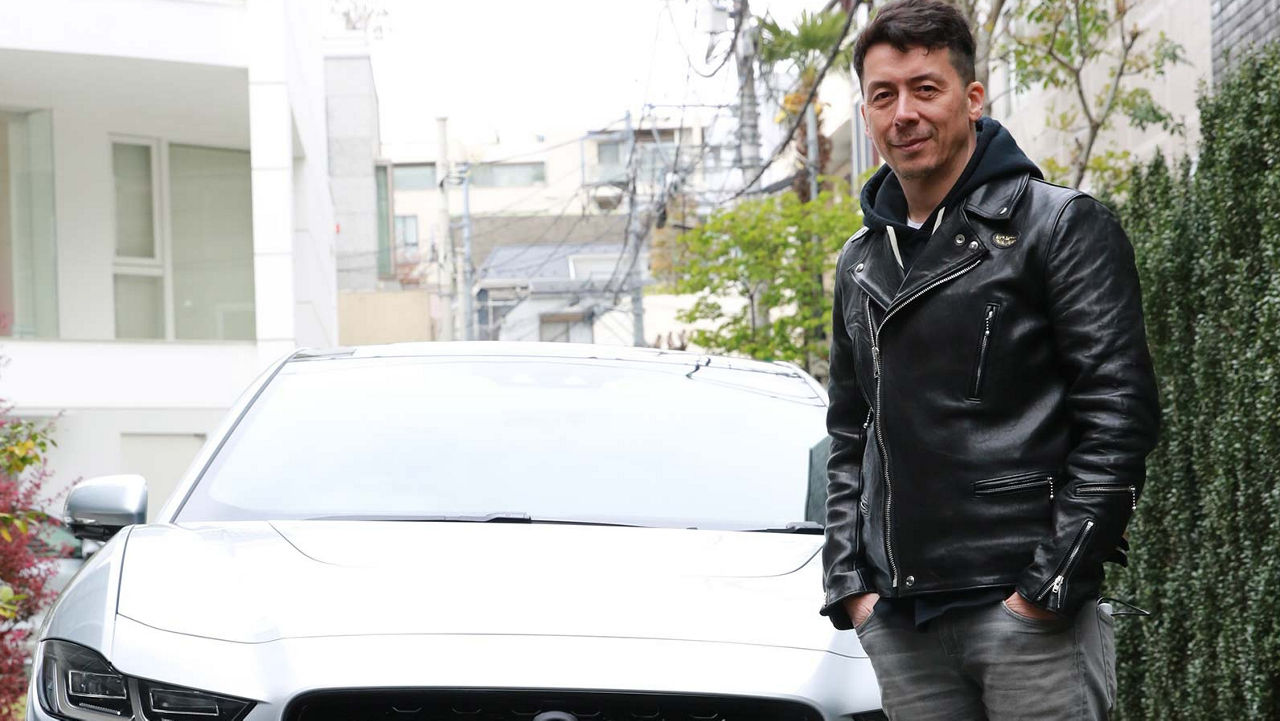 Man standing infront of white jaguar